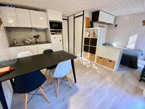 a kitchen with a table and chairs in a room at Bungalow Océane in Léon