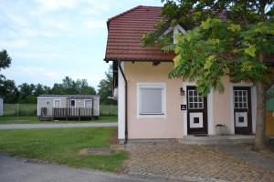 a small white house with a porch and a yard at Aparthouse SUPREME with Terme Catez Swimming Pools Tickets in Čatež ob Savi