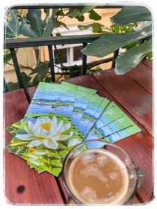 a book and a cup of coffee on a wooden table at Skadar lake Apartments Pajovic in Virpazar