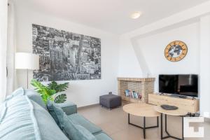 a living room with a blue couch and a tv at Villa Mirador de Bassetes 14 - Grupo Turis in Calpe