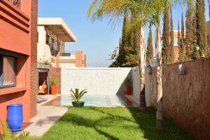 a yard with a fence and palm trees and a house at Atlas Royale Marrakech in Marrakesh