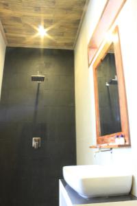 a bathroom with a sink and a mirror at Alam Mimpi Hotel in Lajor