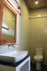 a bathroom with a sink and a toilet at Alam Mimpi Hotel in Lajor