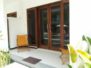 a room with glass doors and a chair on a porch at Alam Mimpi Hotel in Lajor