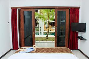a room with a bed and a window with a television at Alam Mimpi Hotel in Lajor