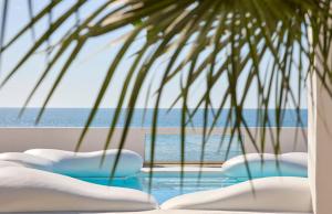 a pool with chairs and a view of the ocean at La Casa E Il Mare, Private Bay Hotel in Mattinata
