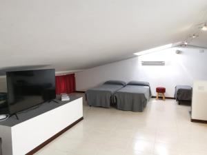 a room with two beds and a flat screen tv at You Welcome Apt in Elmas