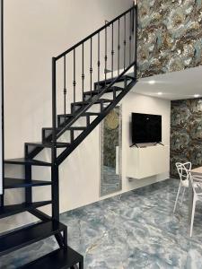 a black staircase in a living room with a tv at Aurora House 2 in Naples
