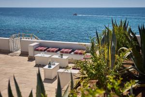 a view of a beach with chairs and the ocean at La Casa E Il Mare, Private Bay Hotel in Mattinata