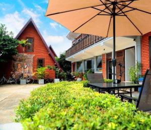 a patio with a table and an umbrella at D Family Resort in Anuradhapura