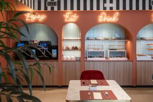 a restaurant with a table and a red chair and signs at Bleis Hotel in Bologna