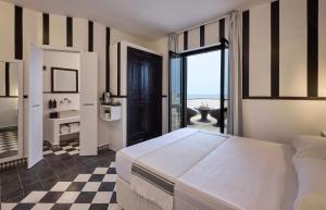 a bedroom with a large bed and a checkered floor at La Casa E Il Mare, Private Bay Hotel in Mattinata