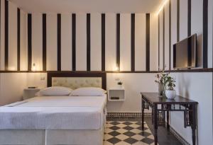 a bedroom with a bed with a black and white striped wall at La Casa E Il Mare, Private Bay Hotel in Mattinata