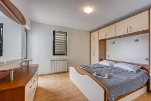 a bedroom with a bed and a desk in it at Apartments Punta in Poreč