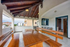 a dining room with a wooden table on a balcony at Apartments Punta in Poreč