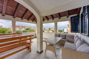 a patio with a wooden bench and a table at Apartments Punta in Poreč