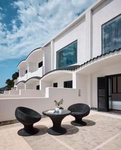 a patio with two chairs and a table in front of a building at La Casa E Il Mare, Private Bay Hotel in Mattinata