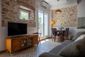 - un salon avec une télévision à écran plat sur une armoire en bois dans l'établissement AT077 Planta baja con jardín privado, à Torredembarra