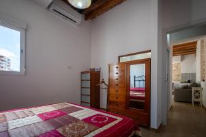 une chambre avec un lit, une commode et un miroir dans l'établissement AT077 Planta baja con jardín privado, à Torredembarra