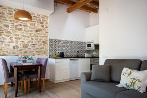 une cuisine et un salon avec un canapé et une table dans l'établissement AT077 Planta baja con jardín privado, à Torredembarra