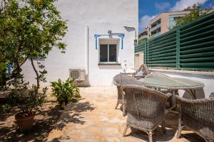 un patio avec une table et des chaises et un bâtiment dans l'établissement AT077 Planta baja con jardín privado, à Torredembarra