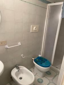 a bathroom with a toilet with a blue seat at Rosa Marina Frontline Beach in Ostuni +37 photos