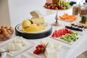 a table topped with plates of cheese and fruit at La Casa E Il Mare, Private Bay Hotel in Mattinata