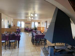 a dining room with tables and chairs with purple table cloth at Auberge de Cadenas in Veyreau