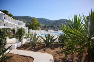 a resort with a swimming pool and palm trees at La Casa E Il Mare, Private Bay Hotel in Mattinata