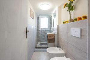 een witte badkamer met een toilet en een wastafel bij Lucca Old Town Apartment in Lucca +11 foto's
