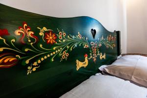 a bedroom with a bed with a painting on the headboard at Casa Cu Usi - House of Doors in Sighişoara