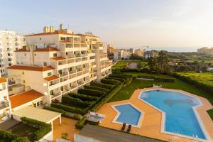 an aerial view of a building with a swimming pool at Seasun Step Apartment in Praia da Rocha in Portimão