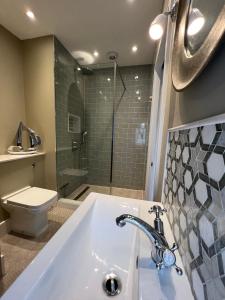 a bathroom with a tub and a toilet and a sink at Cosy 2 bed cottage in beautiful Orford in Orford