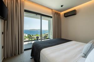 a bedroom with a bed and a large window at NimVie Green Retreat in Skiathos Town +40 photos