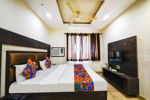a bedroom with a large bed and a flat screen tv at FabHotel Nanda Civil Lines in Ludhiana