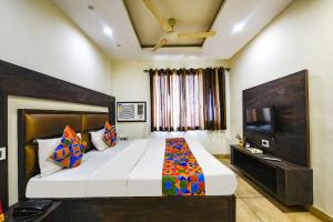 a bedroom with a large bed and a television at FabHotel Nanda Civil Lines in Ludhiana