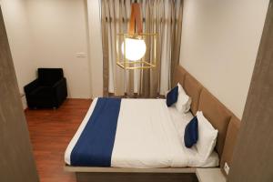 ein Schlafzimmer mit einem großen Bett mit blau-weißer Bettwäsche in der Unterkunft Hotel Suryodaya in Ujjain + 14 Fotos