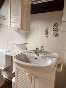 a white bathroom with a sink and a toilet at Barkas 18 in Nieuwpoort