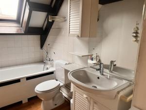 a bathroom with a sink and a toilet and a tub at Barkas 18 in Nieuwpoort