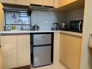 una pequeña cocina con fregadero y lavavajillas en work & chill 깨끗한 compact studio, en Lapu Lapu City 1 foto más