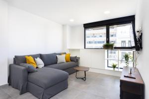a living room with a gray couch and a window at Home2Book Design & Spacious Apartment City Center in Santa Cruz de Tenerife