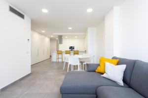 a living room with a blue couch and a table at Home2Book Design & Spacious Apartment City Center in Santa Cruz de Tenerife