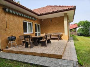 a patio with a table and chairs and a grill at Kopalnia Wspomnień in Kopalino