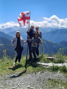 a group of people holding a flag on a mountain at Guest House Old Omalo in Omalo