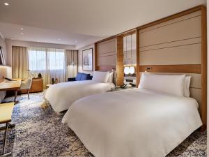 a hotel room with two beds and a desk at InterContinental Barcelona by IHG in Barcelona