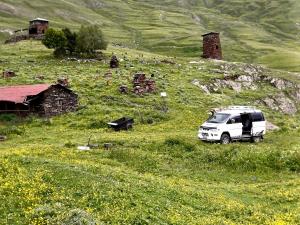 a white van parked in a field of flowers at Guest House Old Omalo in Omalo