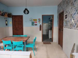 a dining room with a wooden table and blue chairs at Cantinho especial in Recife