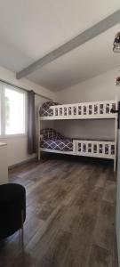 a room with two bunk beds and a wooden floor at Le Petit Clos des Chênes à 2 pas d'Avignon in Villeneuve-lès-Avignon