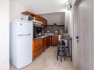 Una cocina con refrigerador blanco y gabinetes de madera. en Il Nido dei Sogni, en Imperia