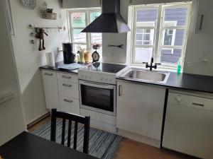 a kitchen with a sink and a stove at Skrædderens Baghus in Assens